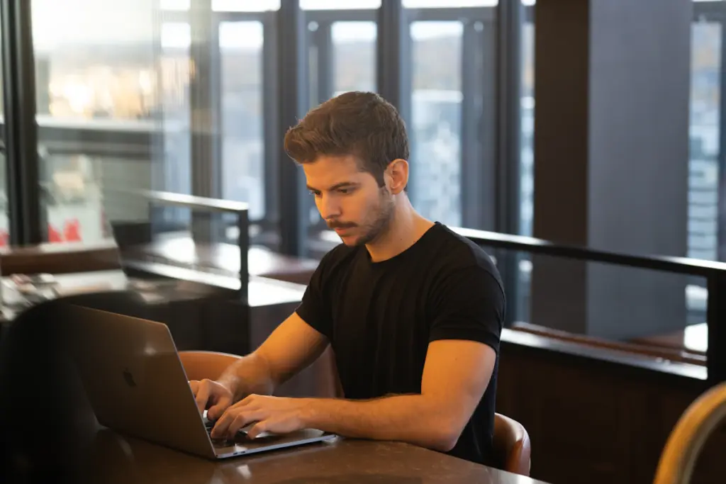 Business owner using a laptop to review online business performance and customer growth